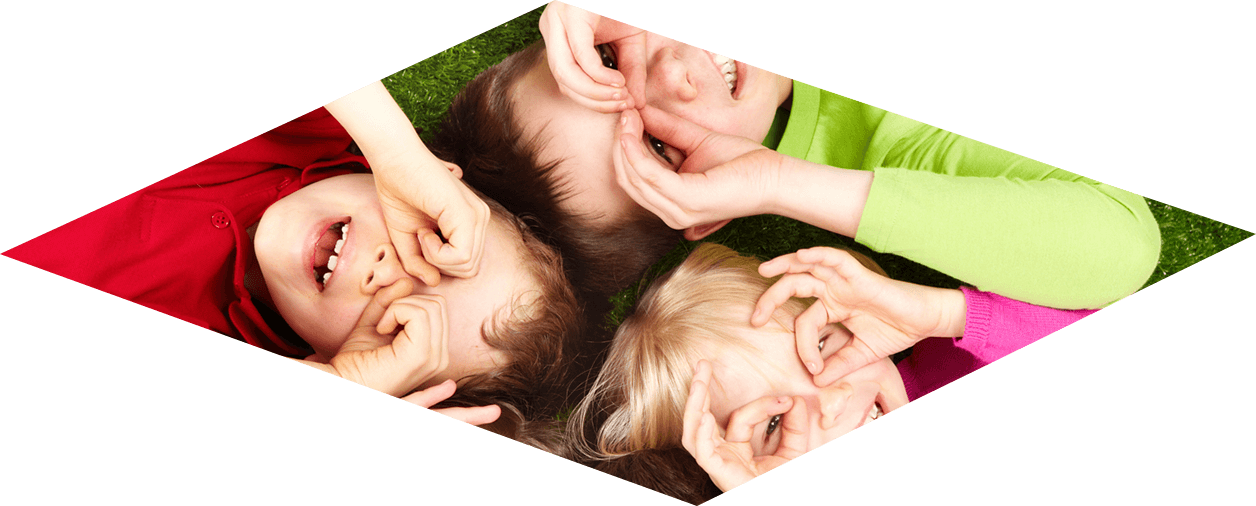 Photo - Children lying on the ground looking through their opened hands